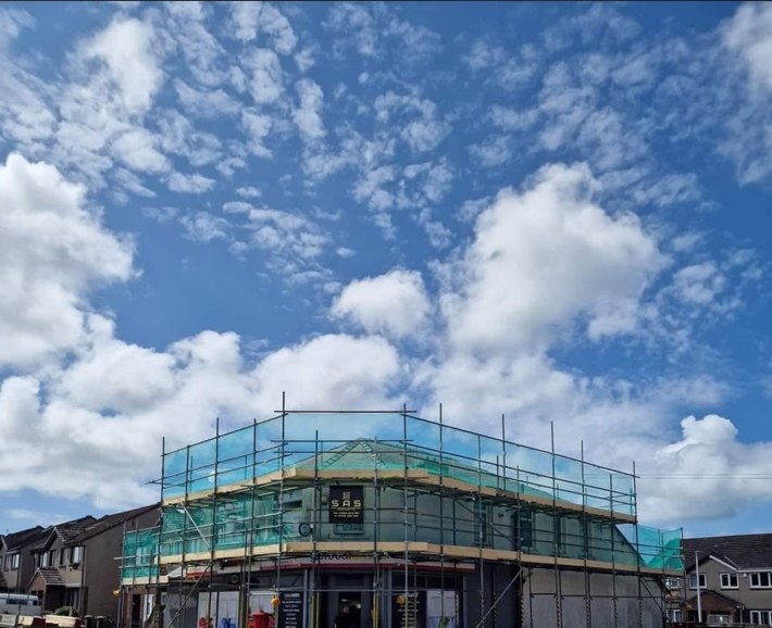 Commercial scaffold with debris netting around a corner property in Cumbria